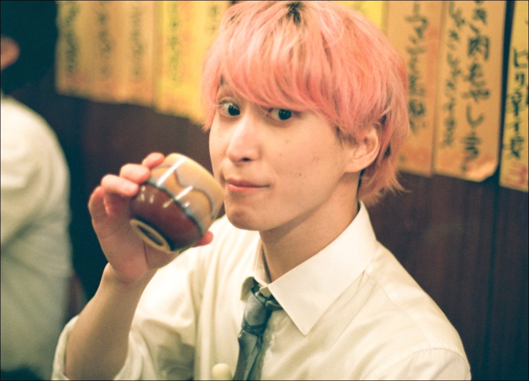 ピンク髪でお茶を飲む佐久間大介